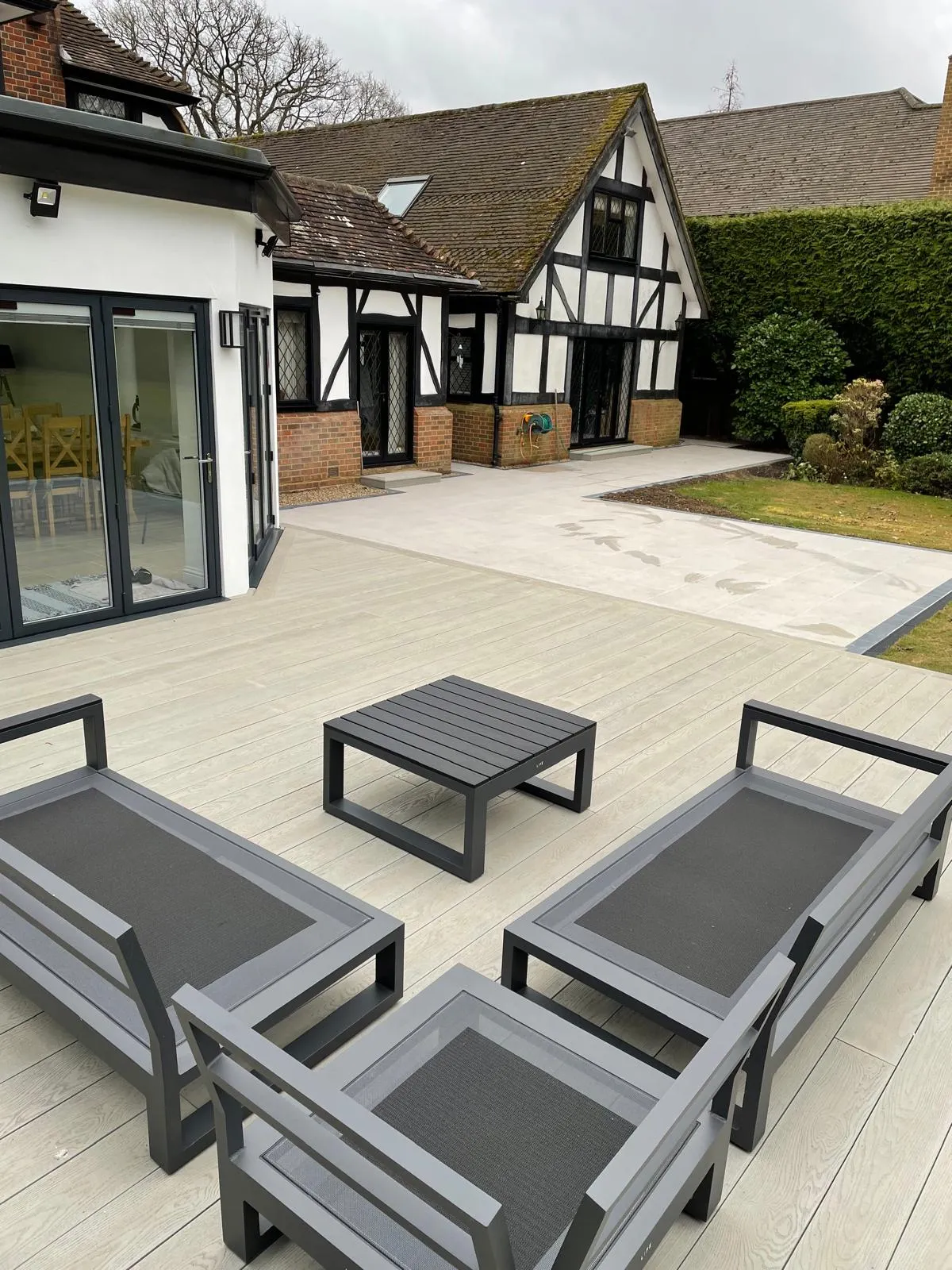 A set of four lounge chairs sitting on top of a wooden deck.